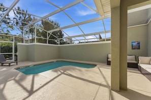 An indoor swimming pool with a glass ceiling, surrounded by lounge chairs and a sofa. - Luxury 4BR Townhome w/ Pool Champions Gate (Kissimmee)