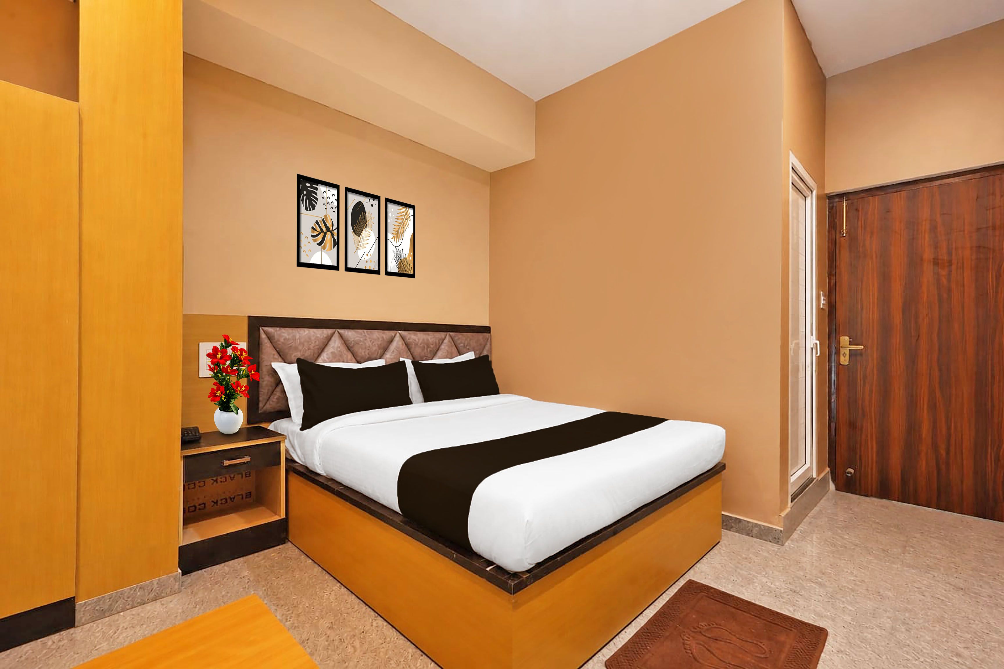 Un dormitorio con cama, mesita de noche y cuadros en la pared.