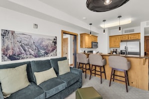 A modern living room with a sofa, two chairs, and a coffee table. - Silverado Lodge by All Seasons Resort Lodging (Park City)