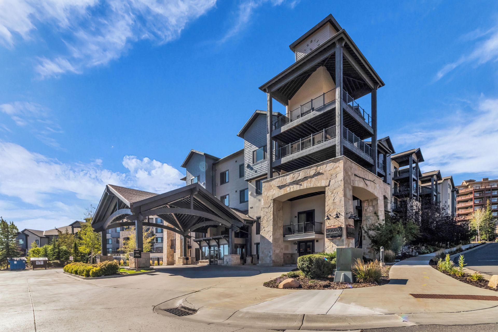 A multi-story hotel with a central atrium, balconies, and a stone facade.