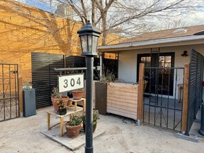 A gated entrance with a sign reading '304' and potted plants.