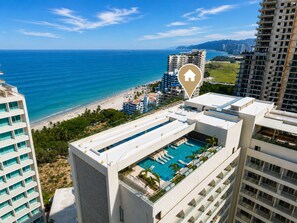A high-rise hotel with a rooftop pool, ocean view, and a beach nearby. - Reserva Apartment – Bello Horizonte by SOHO – 392A (Santa Marta)