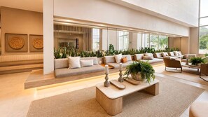 A spacious living area with a large sofa set, a coffee table, and a view of the kitchen through a glass partition. - Reserva Apartment – Bello Horizonte by SOHO – 392A (Santa Marta)