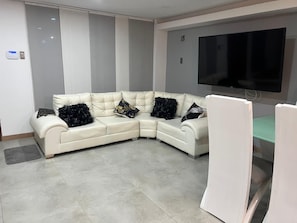 A modern living room with a sectional sofa, a flat-screen TV, and a glass coffee table. - New Listing (Dosquebradas)