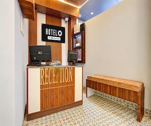 A hotel reception desk with a sign indicating it's serviced by OYO. - Classic Kali Ghat (Prayagraj)
