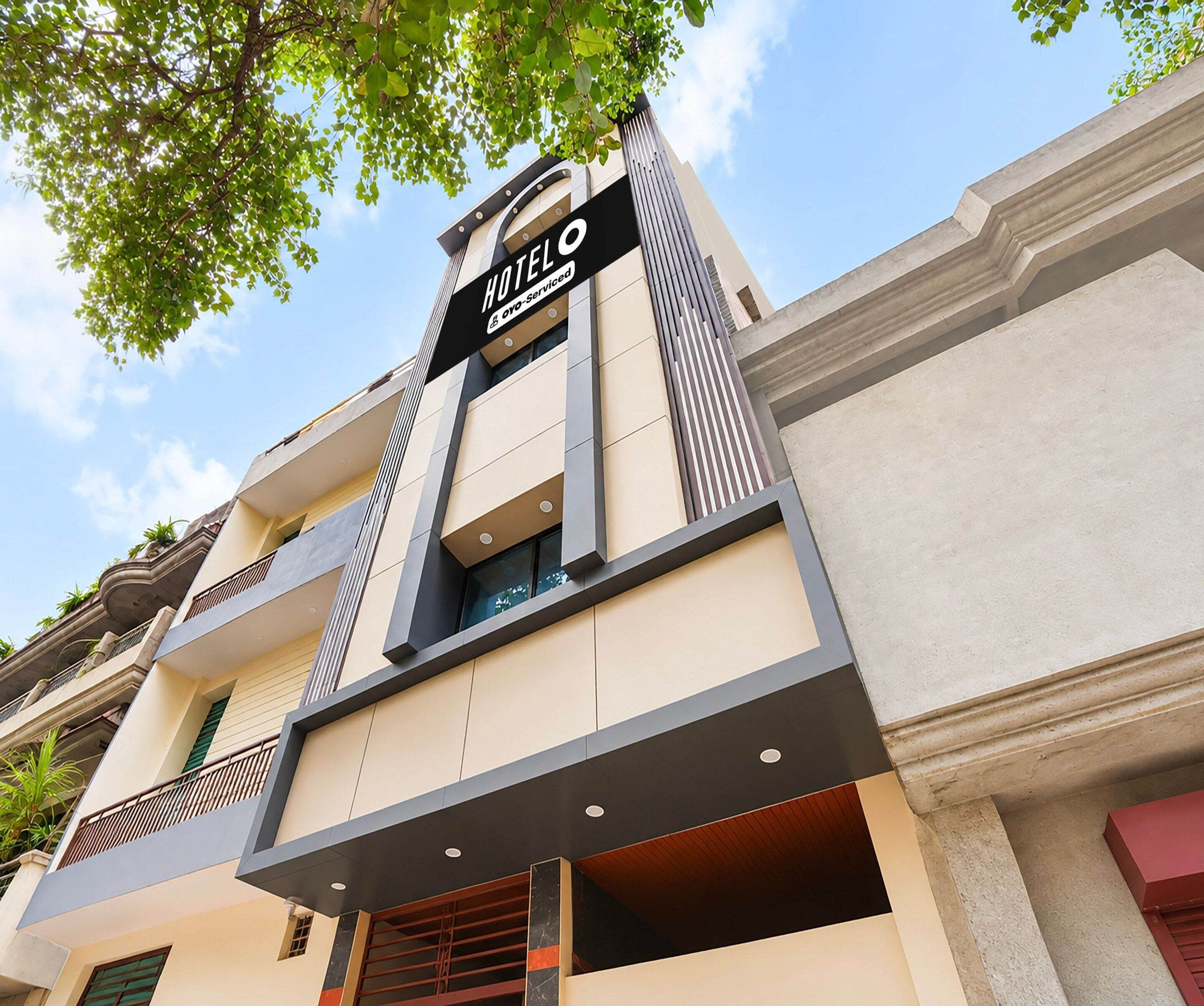 Un hotel con un cartel que indica que pertenece a una cadena hotelera. El edificio tiene varios pisos con balcones y ventanas.