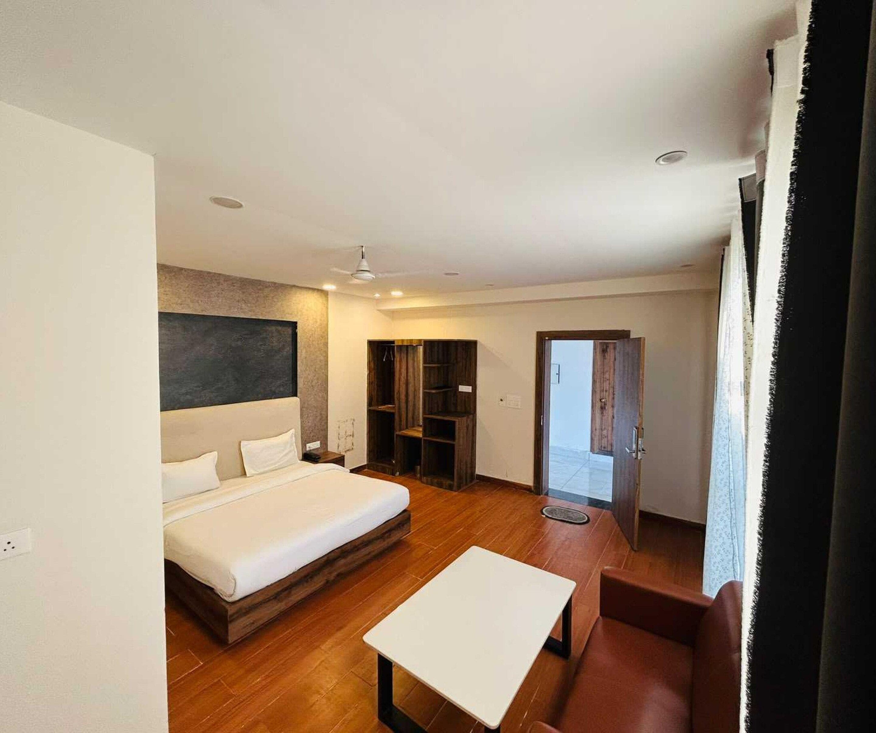 Ett modernt hotellrum med en säng, ett litet bord och en sittgrupp.