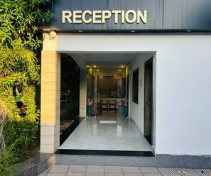 A reception area with a sign, a glass door, and a view into the interior. - Deluxe Red Chilly 3.O (Gorakhpur)