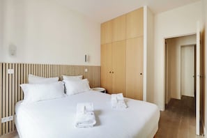 Une chambre d’hôtel avec un lit, une armoire en bois et une porte de salle de bain.
