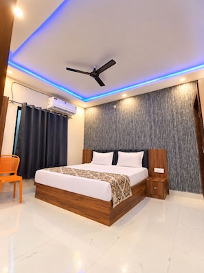 Un dormitorio moderno con cama, ventilador de techo, equipo de aire acondicionado y mesita de noche.