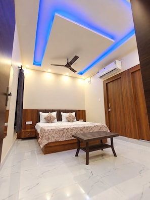 A modern bedroom with a bed, bedside table, ceiling fan, and built-in air conditioning unit.
