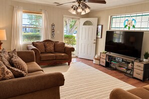 A living room with a brown sofa, a television, and a decorative wall. - Home on the Bayou Cozy 3BR + 2BA Stay in a Quiet Houma Neighborhood (Houma)