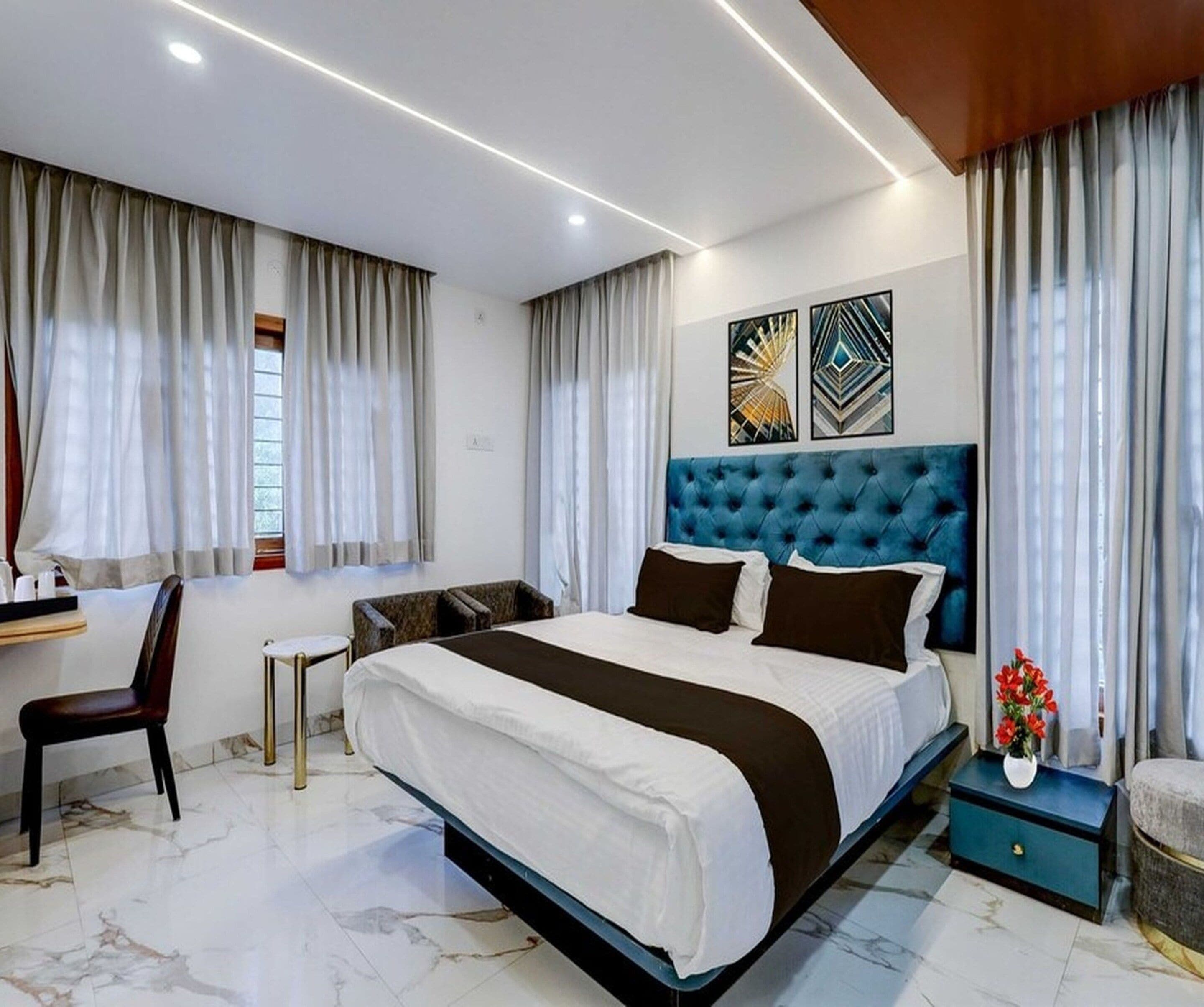 A modern hotel room with a large bed, a desk, and a chair.