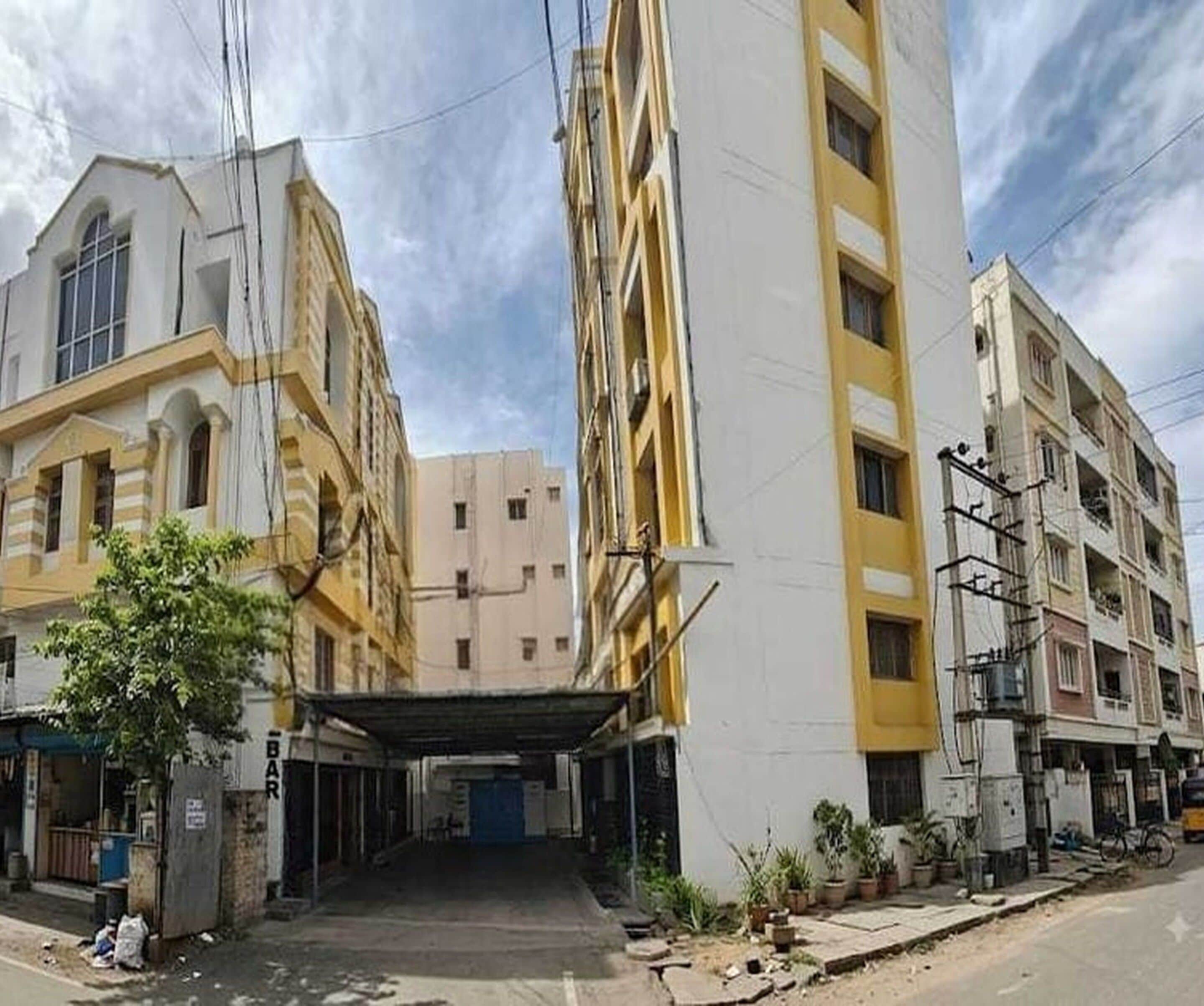 A multi-story building with a central entrance and a covered area.
