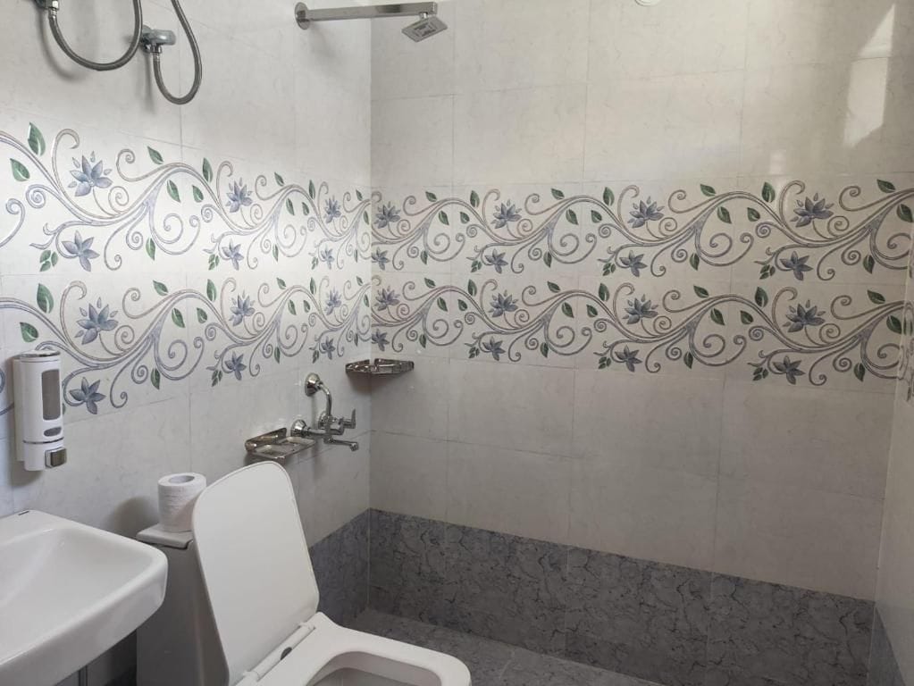 A bathroom with a toilet, sink, and shower area.