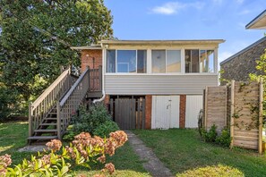 A two-story house with a visible staircase, a garage, and a fenced yard. - Magnolia Garden Home, Hot Tub, Private Garage, Walk to Metro, 4BR/4BA (Washington)