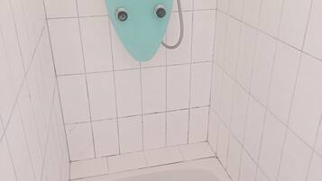 A small, tiled shower enclosure with a single showerhead and a handheld shower attachment.