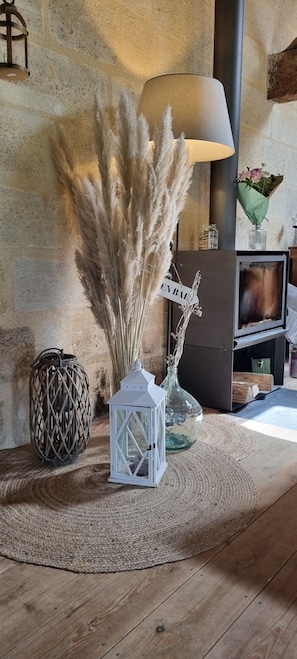 A cozy room with a rustic decor, including a lamp, a TV, and decorative plants.