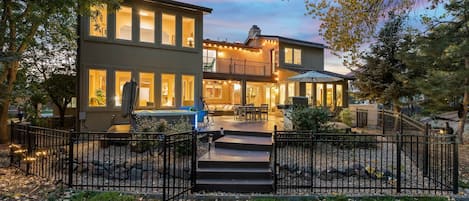 A two-story house with a balcony, a patio, and a stone pathway leading to the entrance.