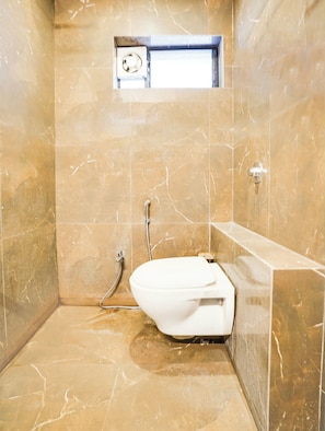 A bathroom with a white bathtub, a shower, and a small window above the bathtub.