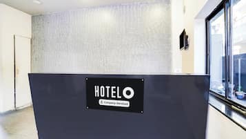 A hotel reception desk with a sign indicating it is company-serviced.