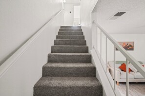 Eine Treppe mit Teppichstufen führt zu einer Zwischenebene.