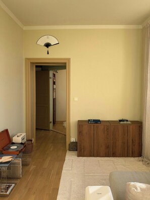A living room with a wooden cabinet, a fan, a record player, and a chessboard. - A travel-curated flat in the heart of Grünerløkka (Oslo)
