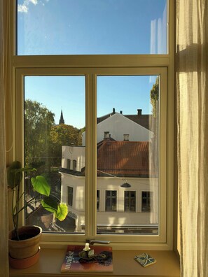 A window with a view of buildings and a church steeple. - A travel-curated flat in the heart of Grünerløkka (Oslo)