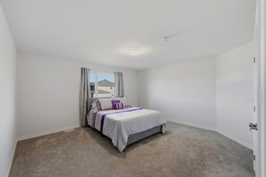A bedroom with a single bed, a window with curtains, and a carpeted floor. - Ottawa Getaway | 4BR Home + Free parking +WI-FI (Ottawa)