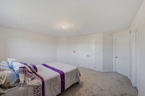 Ein Schlafzimmer mit einem Bett, einem Kleiderschrank und einer Tür.