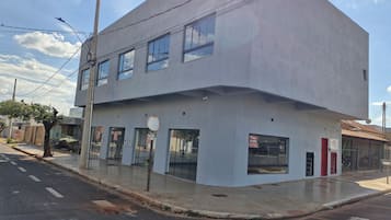 Un edificio de dos pisos con fachada plana, ventanas amplias y escaparate visible.