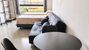 Una sala moderna con un sofá, una mesa redonda y dos sillas.