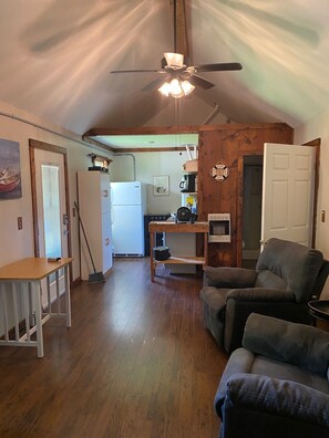 A compact living space with a kitchen, dining area, and seating area. - Tranquil 2-bedroom cottage with AC in charming Corinth (Corinth)