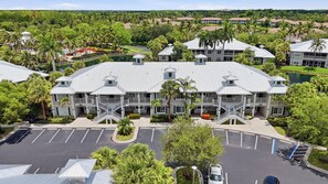 Ein mehrstöckiges Hotel mit Innenhof, umgeben von üppigem Grün und einem Schwimmbad.