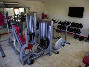A gym with various exercise equipment, including weight machines, a treadmill, and dumbbells. - Cozy bungalow, pets welcome - 5 guests (Sartène)