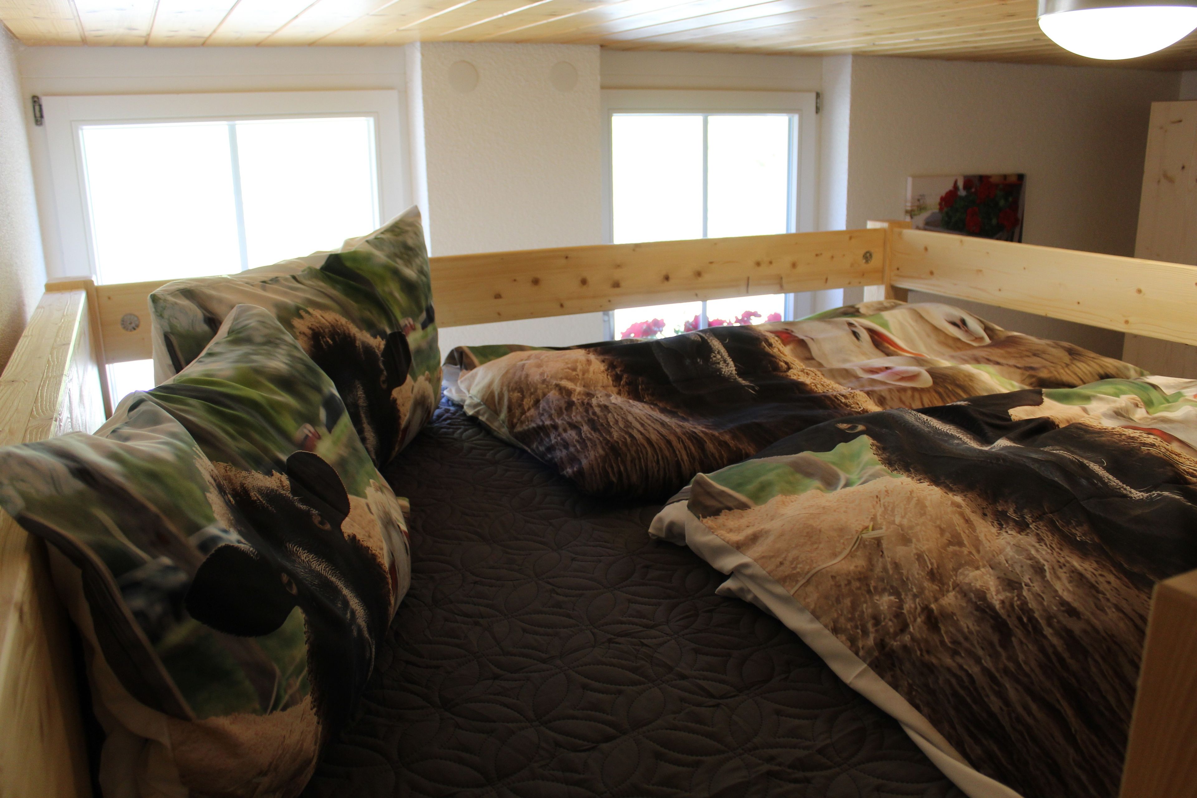 Una cama litera con un cojín estampado de camuflaje y una colcha acolchada.