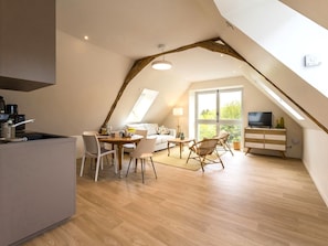 A modern loft apartment with a kitchen, dining area, and living space. - Renovated apartment in town center (La Chapelle-Launay)