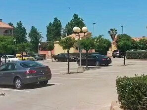 A parking lot with cars, a building with a dome structure, and trees. - F1 cabin with AC and parking - 5 guests (Canet-en-Roussillon)