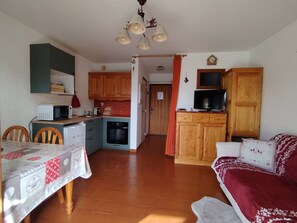 A compact living space with a kitchen, dining area, and a cozy seating area. - Studio near slopes - 2 guests (Crest-Voland)