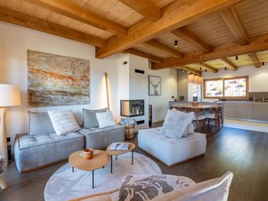 A modern living room with a sofa set, a coffee table, and a fireplace. - Half-chalet beautifully located, mountain view - 6 guests (La Clusaz)