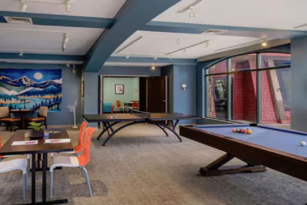 A room with a pool table, a dining area with chairs, and a painting on the wall. - 1 Unit Inside Sheraton Steamboat Resort Villas (Steamboat Springs)