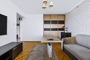 Ein modernes Wohnzimmer mit einer Couch, einem Couchtisch, einem Fernseher und einem Kamin.
