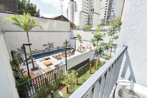 A rooftop pool area with lounge chairs and potted plants. - StayHome Vila Clementino Nurban - Pool  (São Paulo)