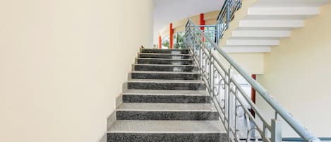 A staircase with black granite steps and metal railings, leading to an upper floor.