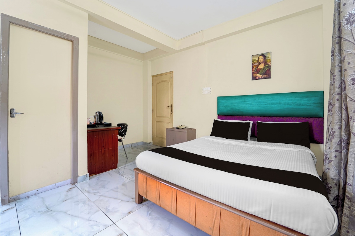 Una habitación de hotel con cama, escritorio, silla, armario y puerta.