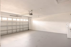 A clean, white garage with a tiled wall and a metal shelving unit. - 3bd/2ba Amazing Villa 10min->disney (Kissimmee)