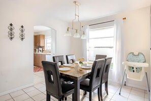 A dining area with a marble table, black chairs, and pendant lights. - 3bd/2ba Amazing Villa 10min->disney (Kissimmee)