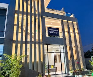 A modern building with a sign reading 'TOWNHOUSE & OFF ROAD' indicating a residential property. - Deluxe Room Hotel Expression (Indore)
