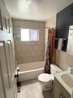 A bathroom with a bathtub, toilet, and a shower. - Charming Vintage Home On A Quiet St (Sterling Heights)