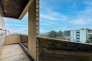 Un balcón con vista a un paisaje urbano, que incluye edificios y un puente.